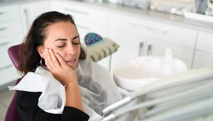 A woman with toothache at the dentist's clinic.